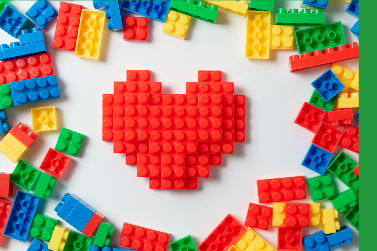 Heart built with red LEGOs surrounded by more LEGOs. 