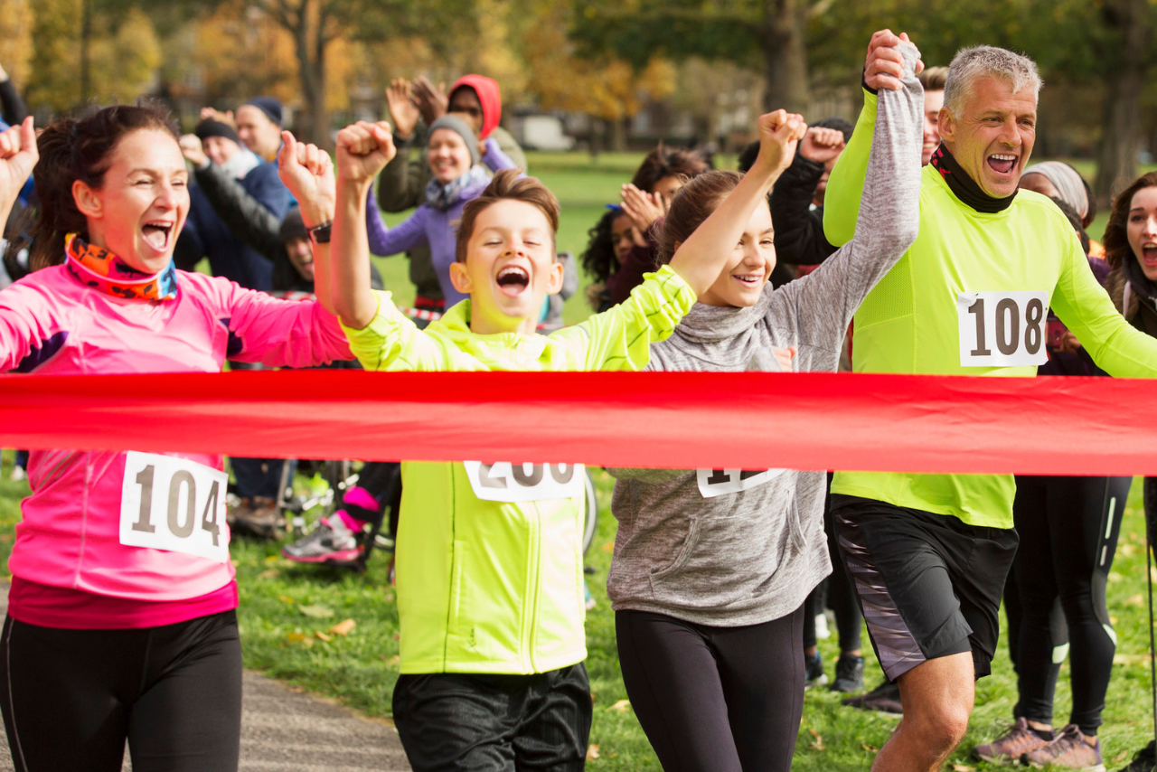 A family competing in a running race crossing the finish line. 
