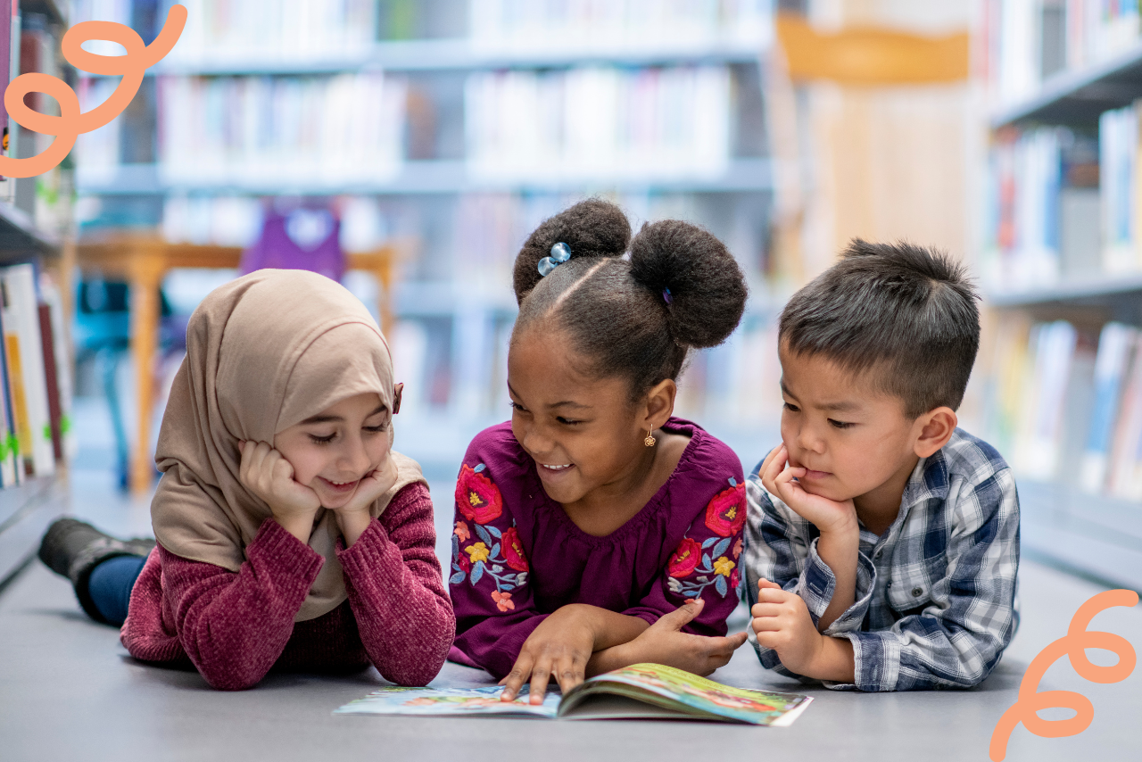 Three kids reading a book together. 