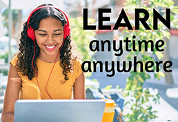 Young woman wearing red headphones, smiling while working on a laptop. Text over photo reads LEARN anytime, anywhere. 