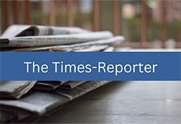 stack of rumpled newspapers on a deck. Blue banner reads The Times-Reporter in white text.