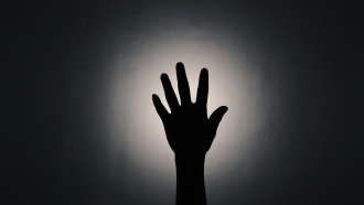photo of a hand in front of a light source. The hand appears to be shadowed. 