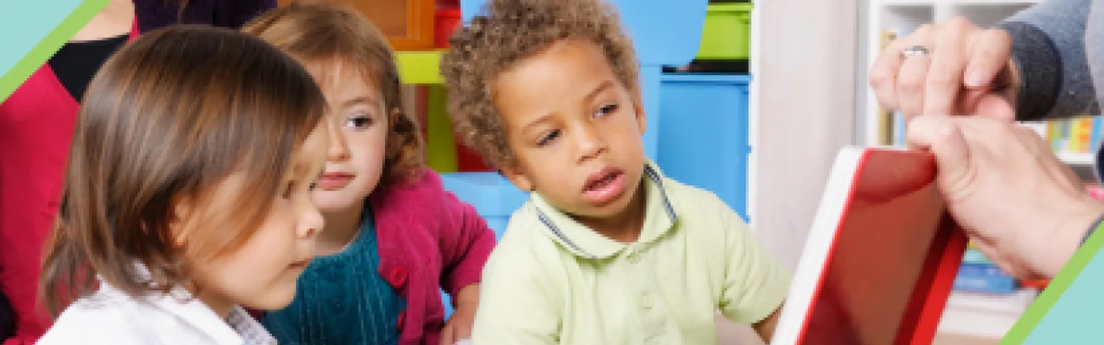 A person holding open a book for Storytime as kids watch.