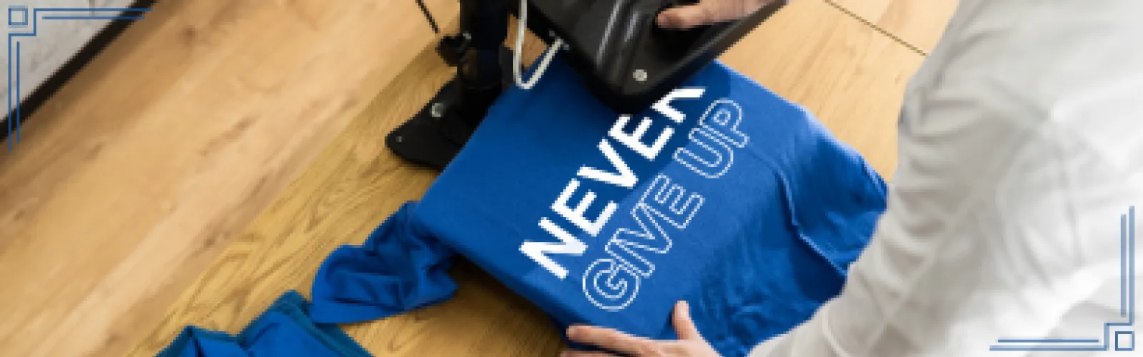 Person using a heat press to print onto a shirt. Shirt stats never give up in bold white vinyl lettering. 