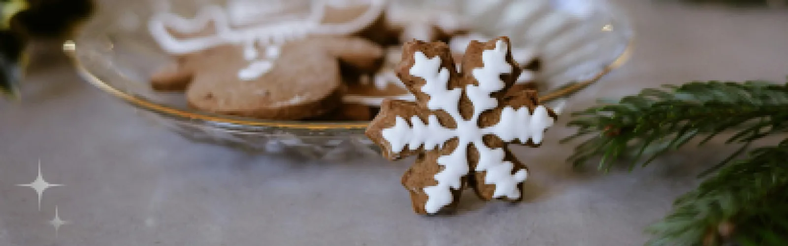 Snowflake gingerbread cookies  with white icing on a glass plate. 