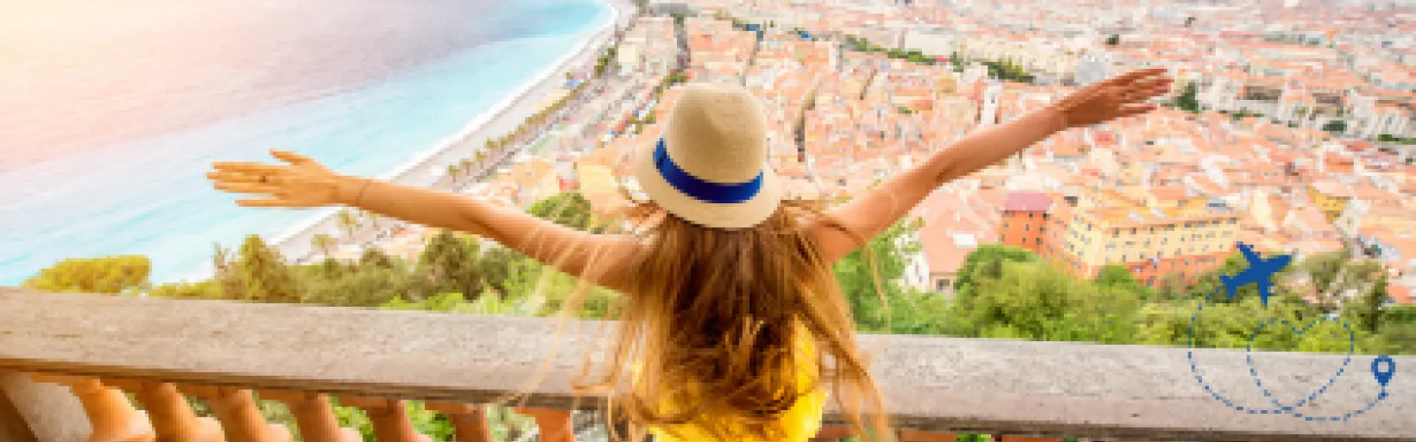 Back of a blonde woman standing on a balcony overlooking the ocean and city below.. 